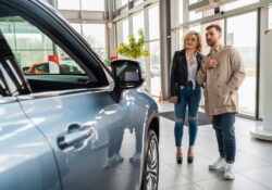 Beautiful couple in car dealership chooses car