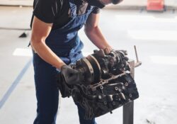 Professional repairman works with broken automobile engine