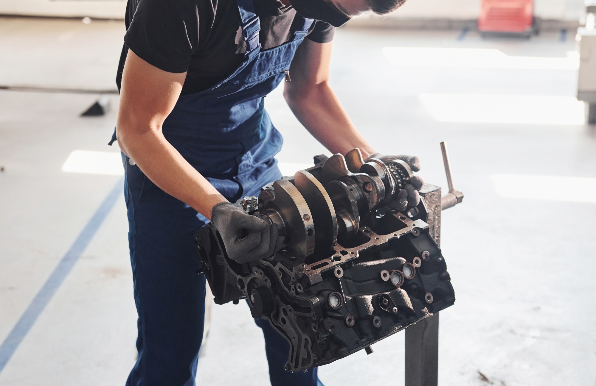 Professional repairman works with broken automobile engine