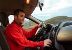 young man tuning into his car radio