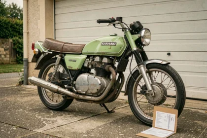 Kawasaki KZ 400 ancienne des années 70 garée devant un garage avec un dossier d'assurance posé contre la roue arrière